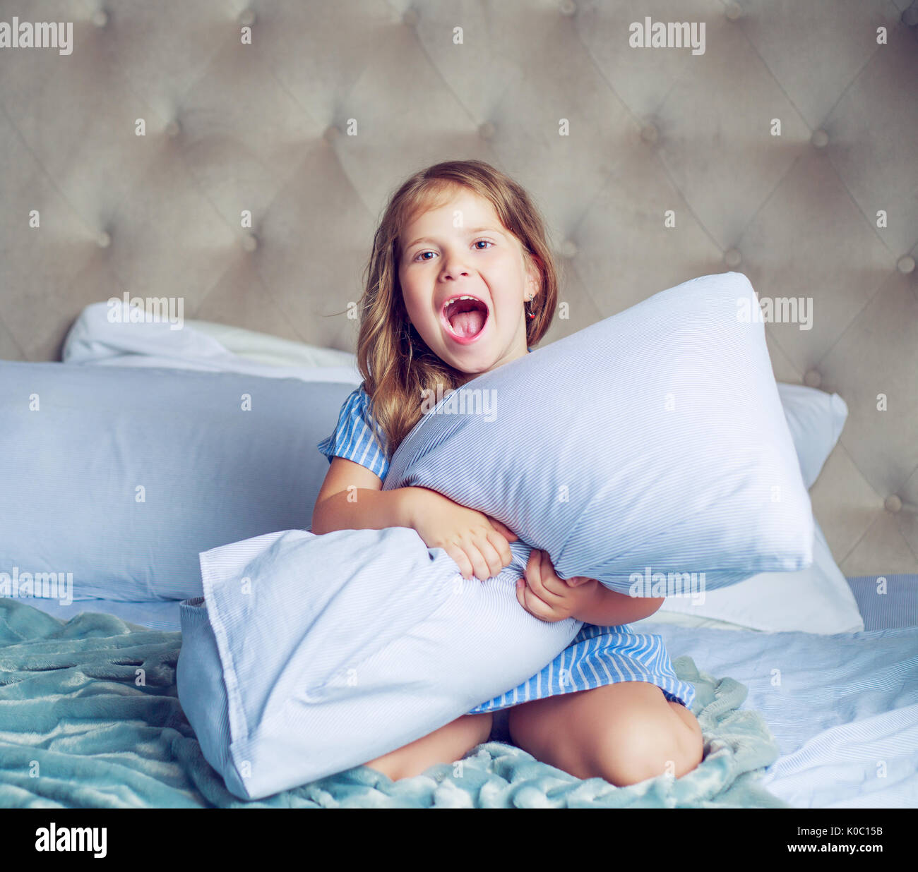 Felice ragazza nel letto di casa Foto Stock