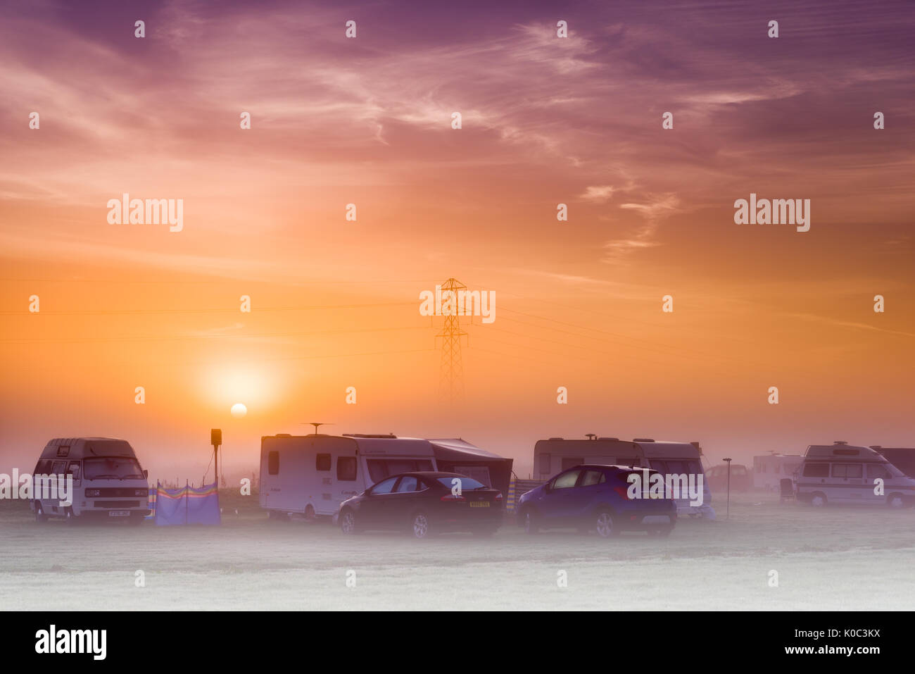 Il sole sorge su una nebbiosa campeggio nel Regno Unito all alba di un agosto di mattina. Foto Stock