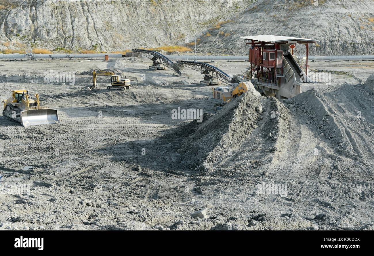 Escavatore in un chalk roccia cava. industria mineraria Foto Stock