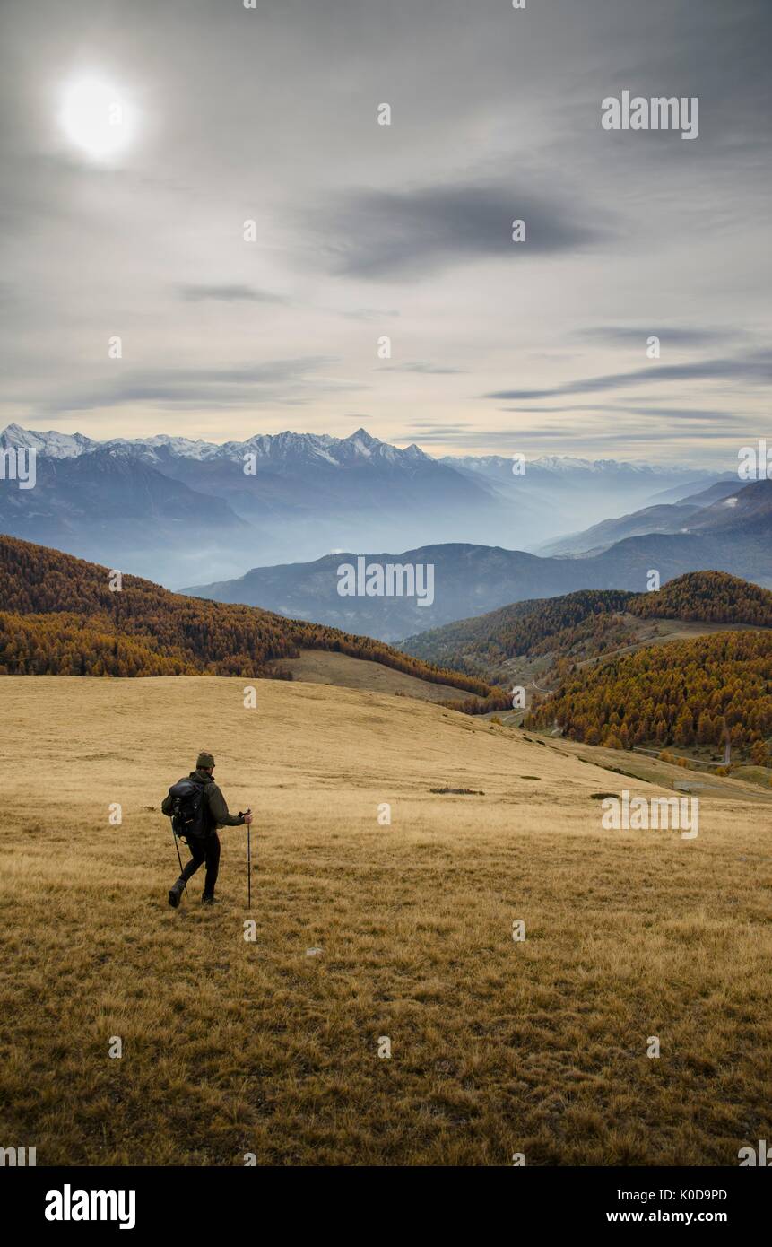 Escursionista che è in discesa nel paesaggio autunnale (Valtournenche, Valle d'Aosta, Italia) Foto Stock