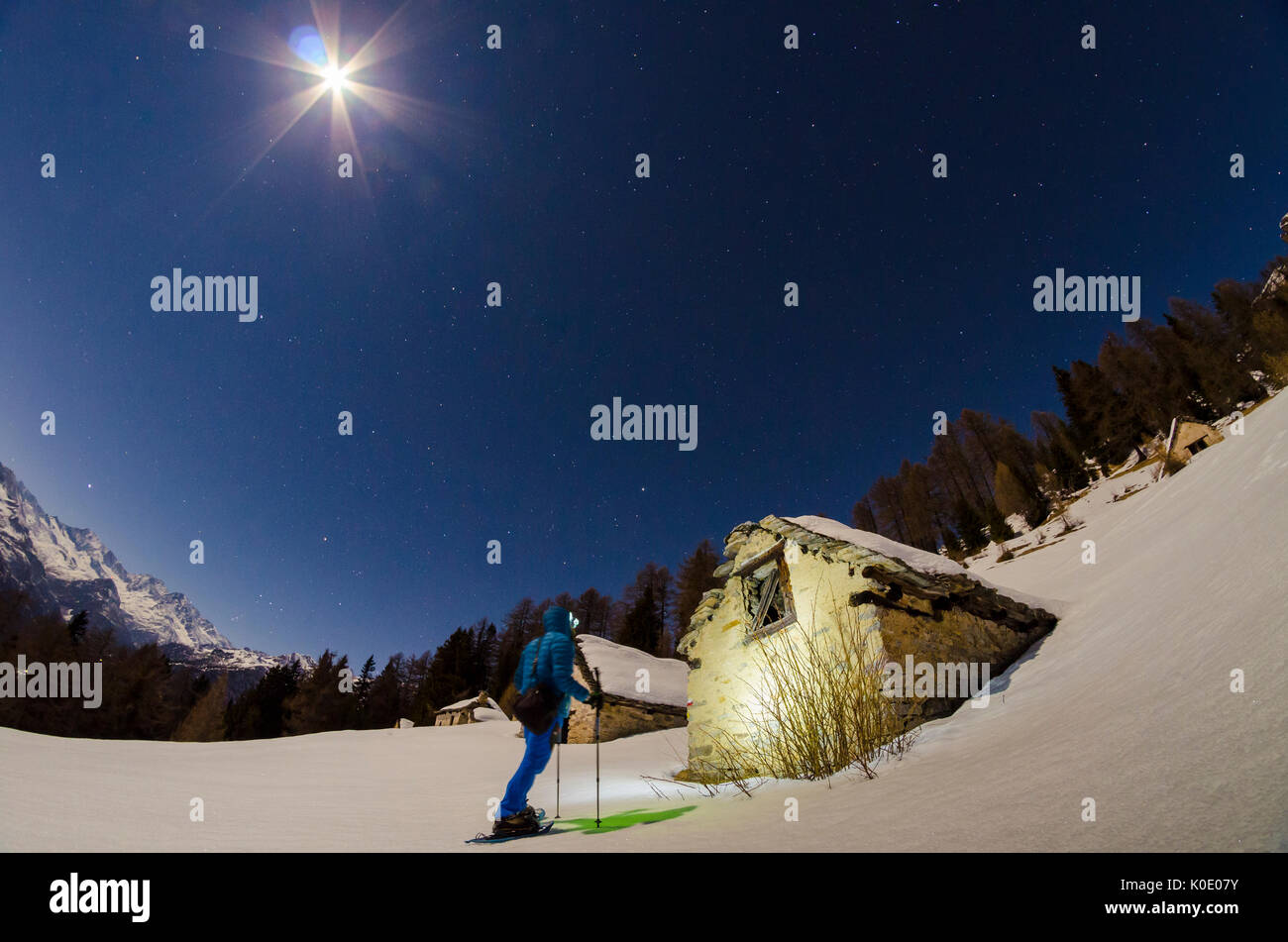 Escursionista nella parte anteriore di una casa a Alpe Il Rono (Divedro Valle Ossola, Piemonte, alpi italiane) Foto Stock