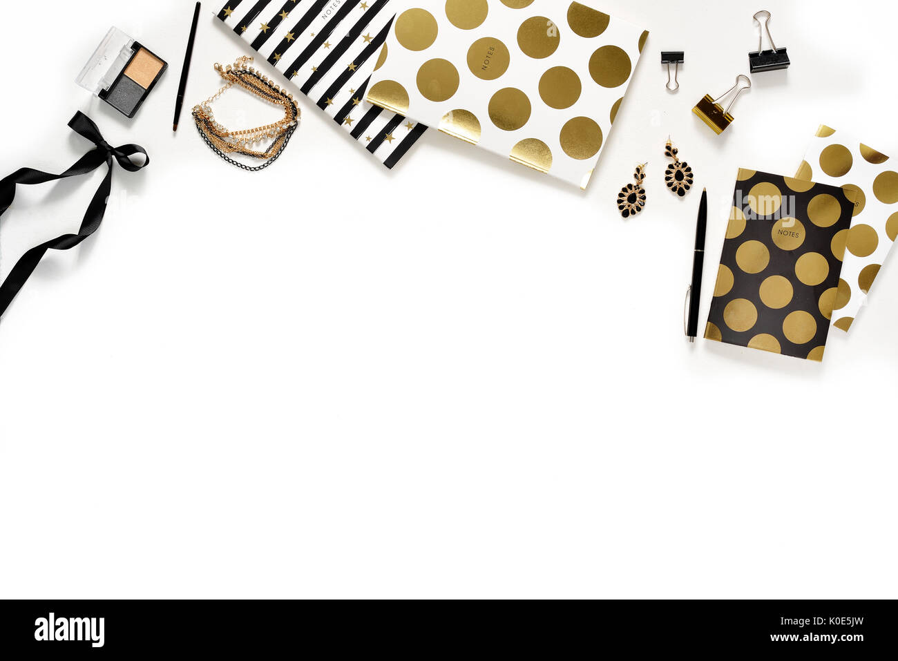 Appartamento laico femminile di moda home office area di lavoro con telefono, tazza di caffè nero elegante notebook d'oro, di cosmetici e di gioielli su sfondo bianco. vista dall'alto sulla donna lavoro di business desk Foto Stock