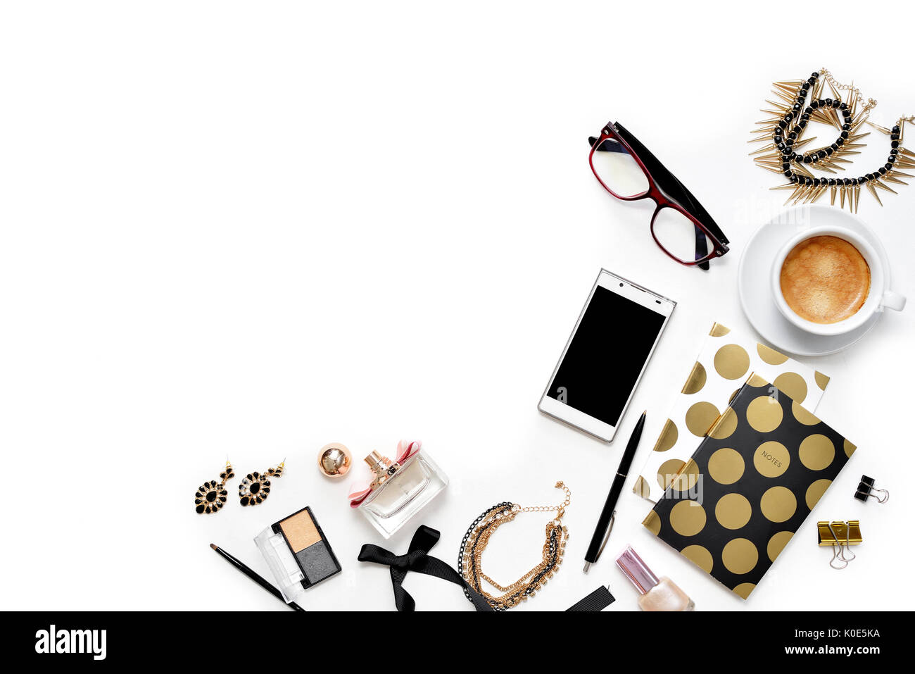 Appartamento laico femminile di moda home office area di lavoro con telefono, tazza di caffè nero elegante notebook d'oro, di cosmetici e di gioielli su sfondo bianco. vista dall'alto sulla donna lavoro di business desk Foto Stock