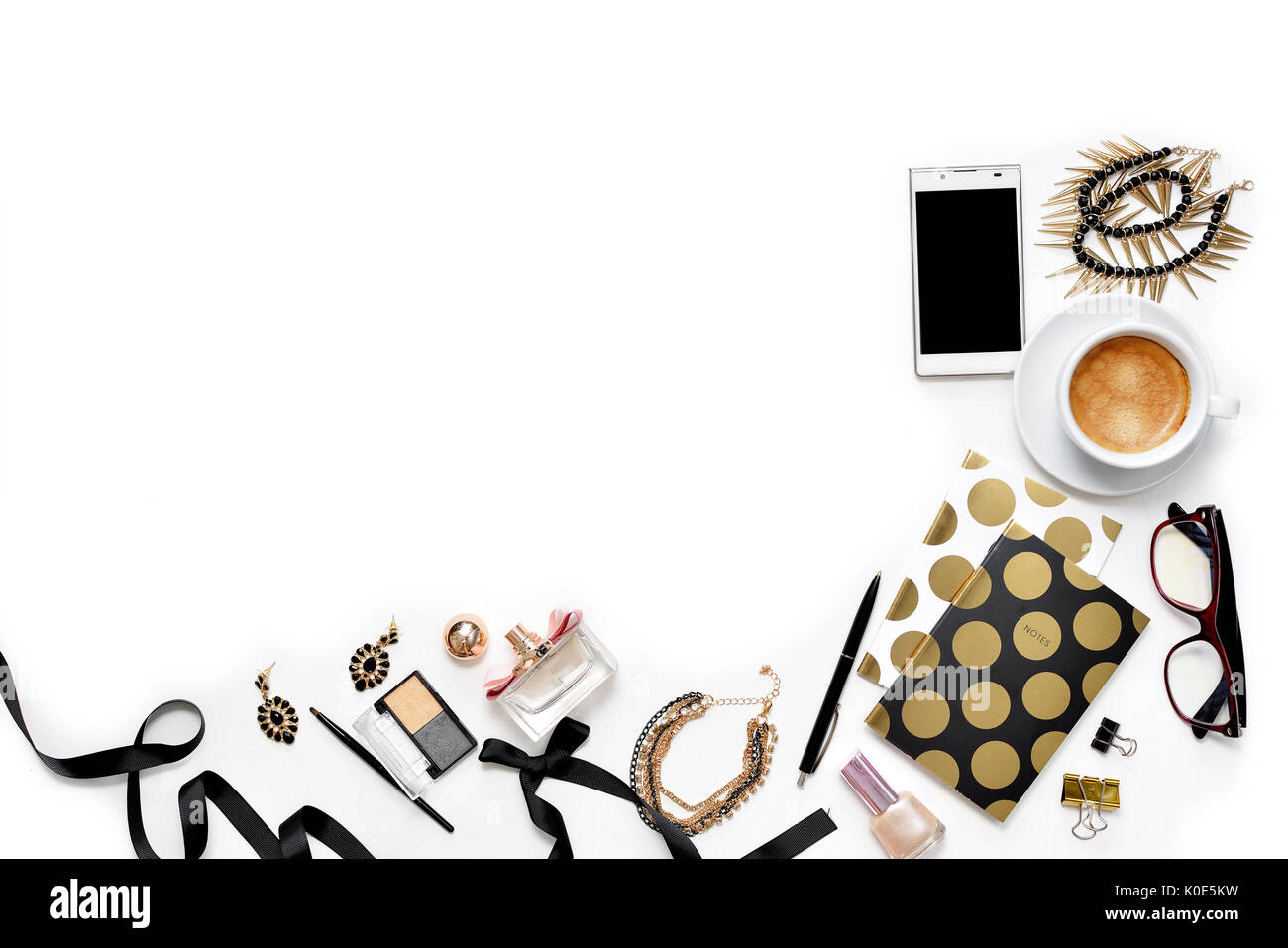 Appartamento laico femminile di moda home office area di lavoro con telefono, tazza di caffè nero elegante notebook d'oro, di cosmetici e di gioielli su sfondo bianco. vista dall'alto sulla donna lavoro di business desk Foto Stock