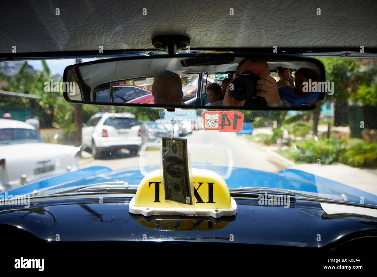 Cubano, Cuba, capitale, l'Avana all'interno di un classico american taxi guardando attraverso il parabrezza cruscotto Foto Stock