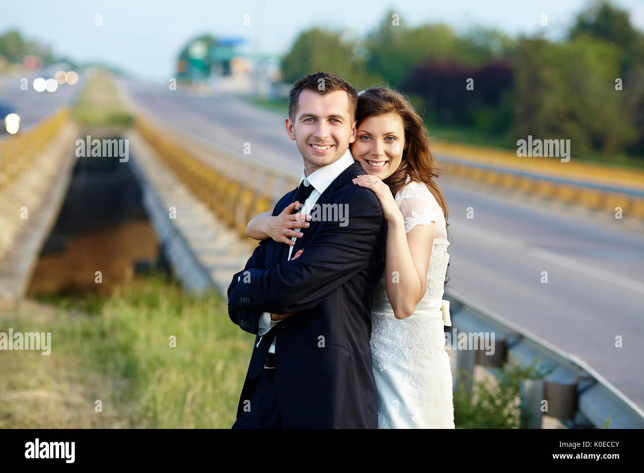 Felice sposa e lo sposo a ridere a sorridere su strada su un matrimonio Foto Stock