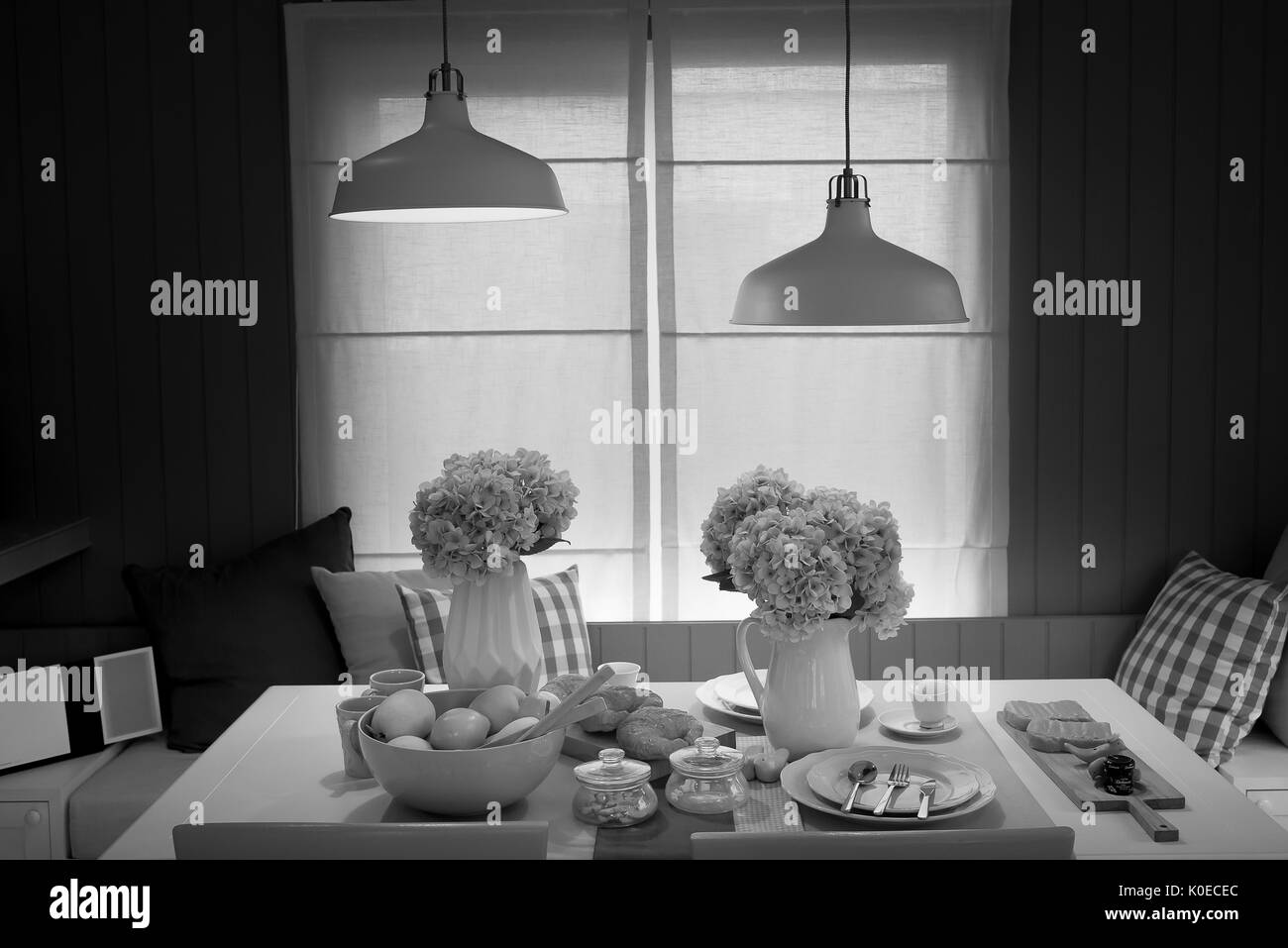 La luce bianca che pende dal soffitto piano al di sopra di un tavolo da pranzo. Foto Stock