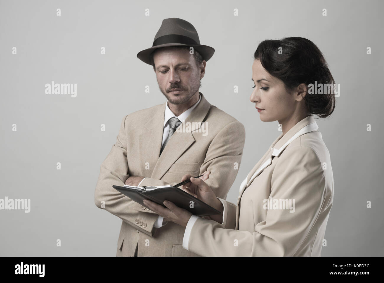 Vintage manager e segretario lavorando insieme controllare le note e gli appuntamenti Foto Stock