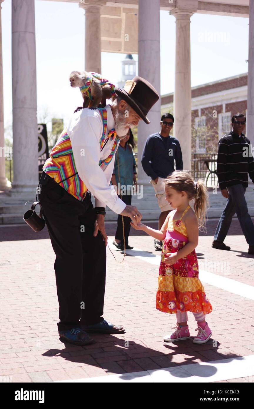 Un animatore con una scimmia sulla schiena interagisce con un giovane bambino durante la fiera di primavera, un festival annuale di musica, cibo, negozi, e più che si svolge ogni anno in primavera su homewood campus della Johns Hopkins University di Baltimora, Maryland. 2014. cortesia eric chen. Foto Stock
