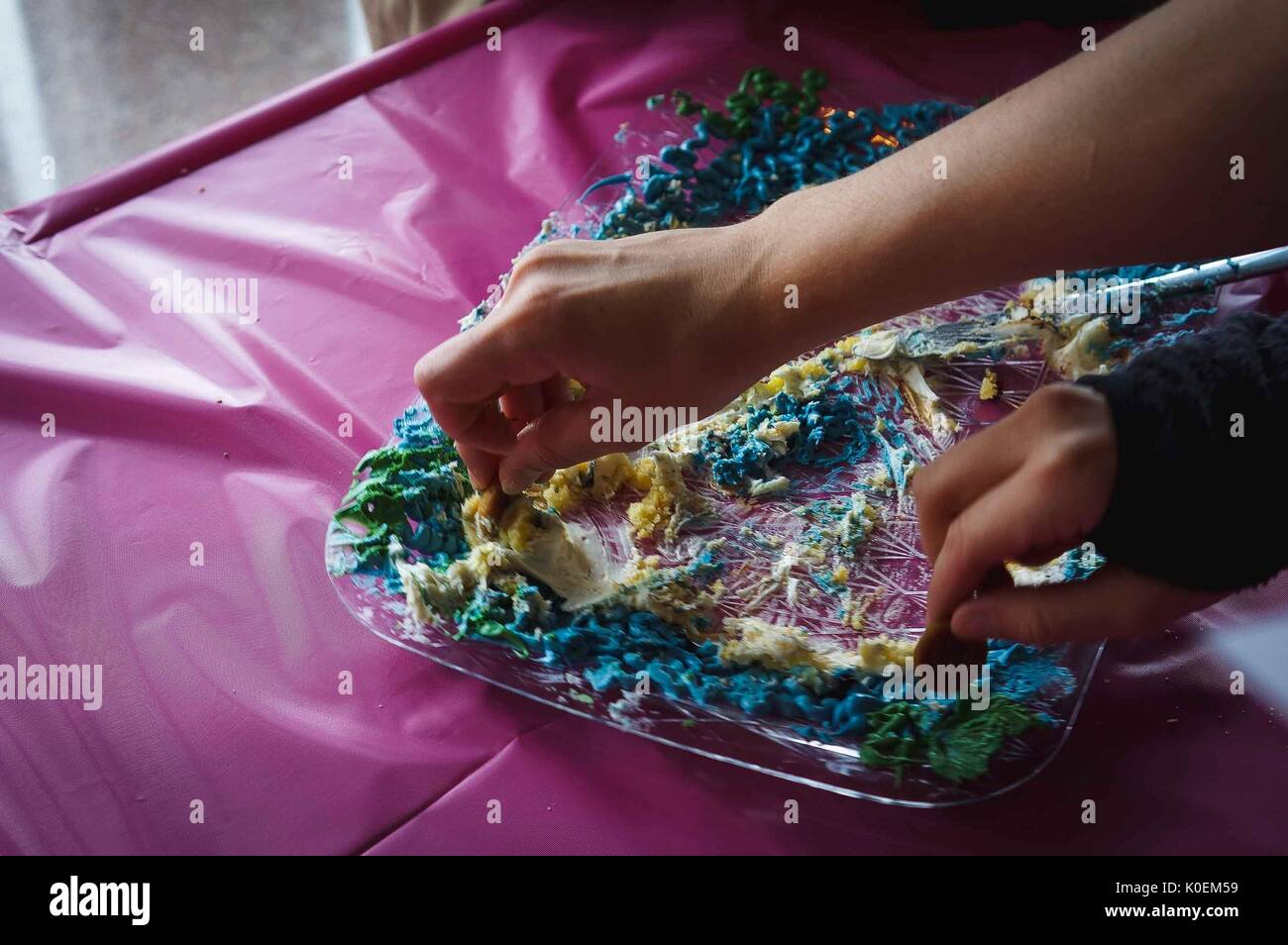 Studenti del college dip i cookie in una torta per afferrare alcune di gusto a prodotti commestibili book festival, aprile 2014. cortesia eric chen. Foto Stock