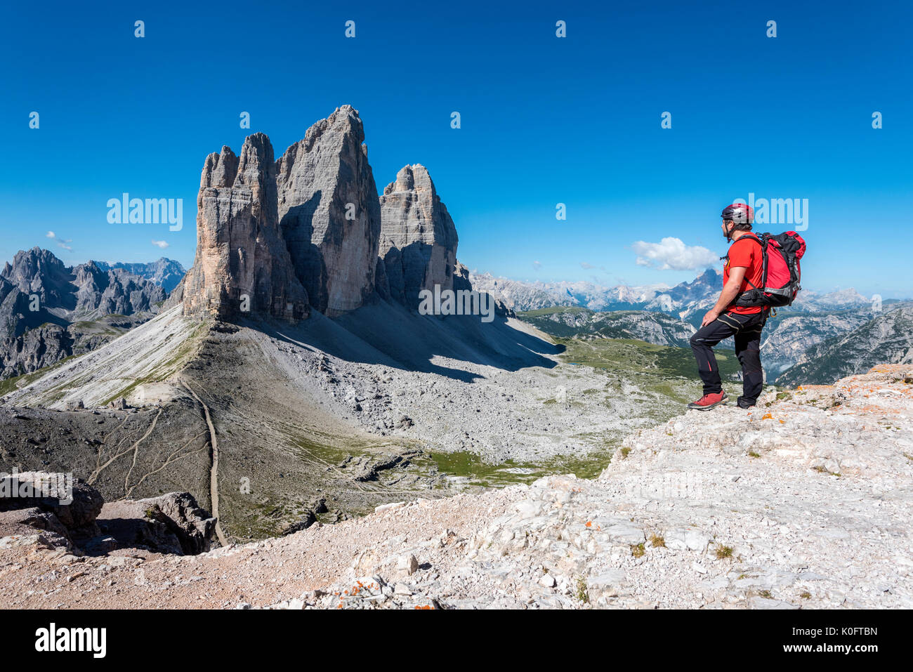 Di Sesto, Dolomiti, Alto Adige, provincia di Bolzano, Italia. Scalatore ammira le Tre Cime di Lavaredo/Drei Zinnen Foto Stock