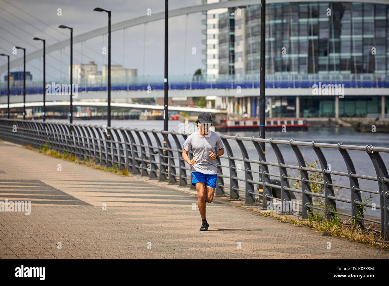 Manchester MediaCityUK a Salford Quays, fare jogging lungo il terrapieno Foto Stock