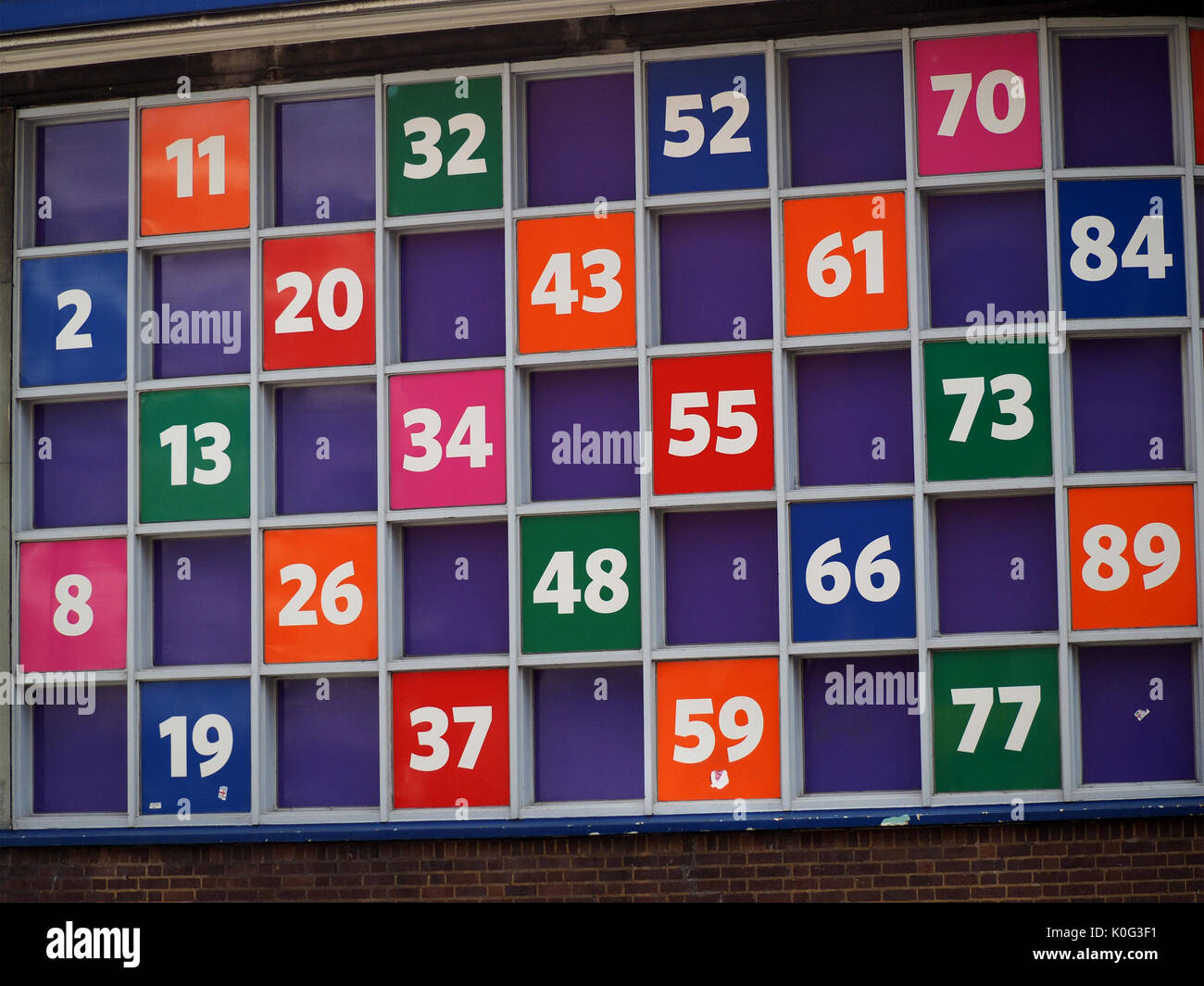 Numeri colorati di un una griglia che simulano un Bingo scheda su un grande cartello pubblicitario al di fuori del Bingo stabilimento in Sheffield, West Yorkshire, Inghilterra, Regno Unito Foto Stock