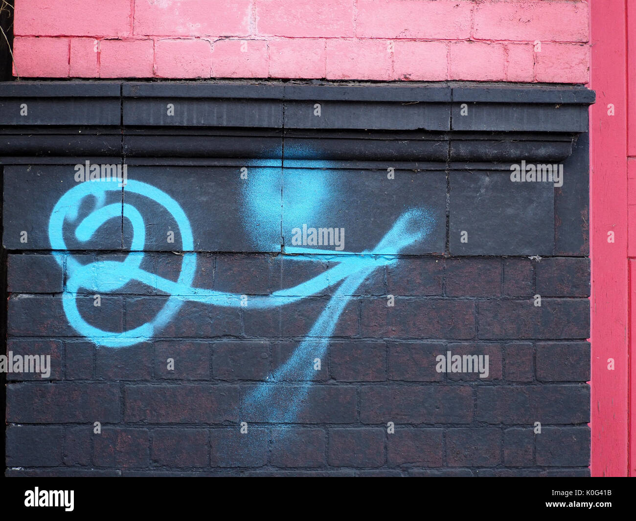 Graffiti sul dipinto luminosamente rosa e nero dipinto di muratura di un edificio vittoriano in Sheffield, West Yorkshire, Inghilterra, Regno Unito Foto Stock