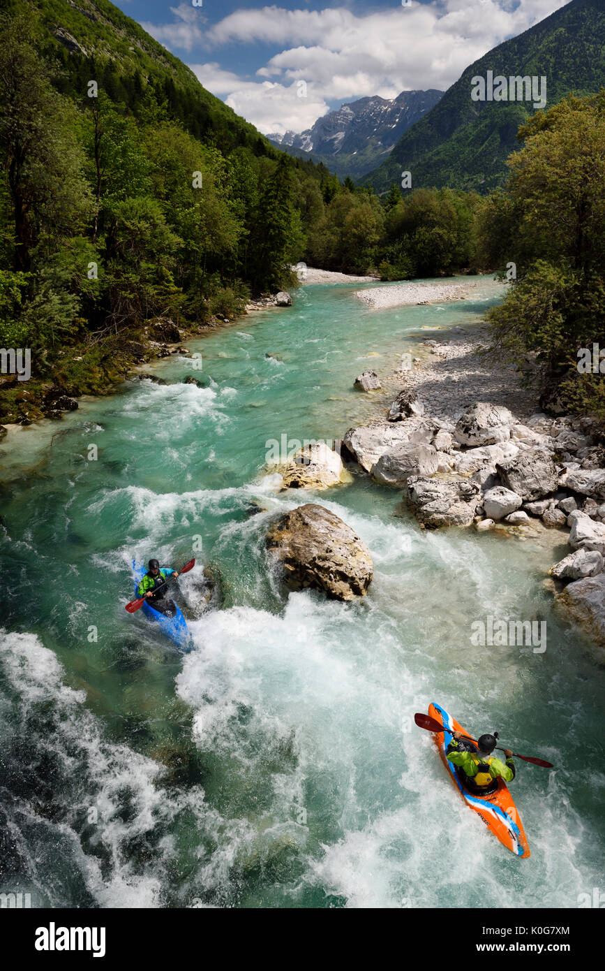 Kayakers riprese il freddo verde smeraldo acqua alpina della tomaia Soca River vicino a Bovec Slovenia con Veliko Spicje montagna nelle Alpi Giulie Foto Stock