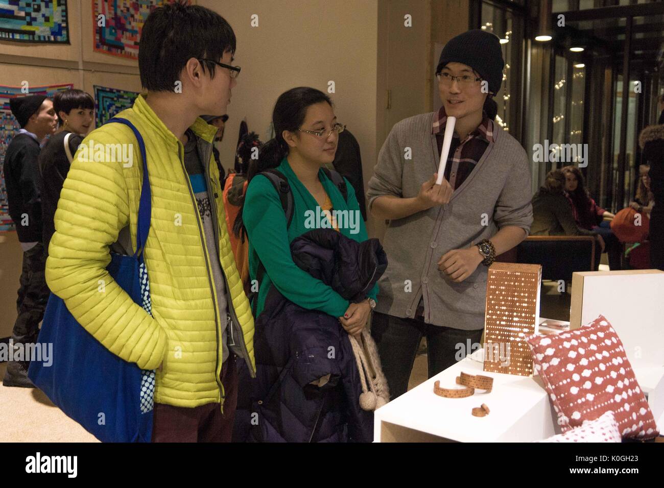 Gli studenti del college guardano gli oggetti esposti durante l'apertura della mostra d'arte "Unravel the Code", una collaborazione tra gli studenti del Maryland Institute College of Art e della Johns Hopkins University, presso la Milton S. Eisenhower Library nel campus di Homewood della Johns Hopkins University a Baltimora, Maryland, 2013. Cortesia Eric Chen. Foto Stock