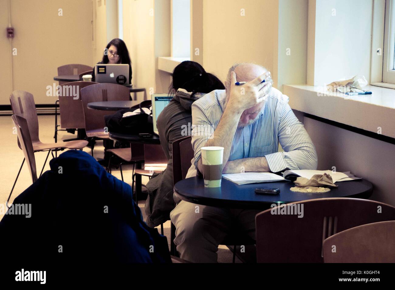 Gli studenti universitari e un professore si trovano a piccoli tavoli, al lavoro, sul Q-Level della Milton S. Eisenhower Library nel campus Homewood della Johns Hopkins University di Baltimora, Maryland, 2014. Cortesia Eric Chen. Foto Stock