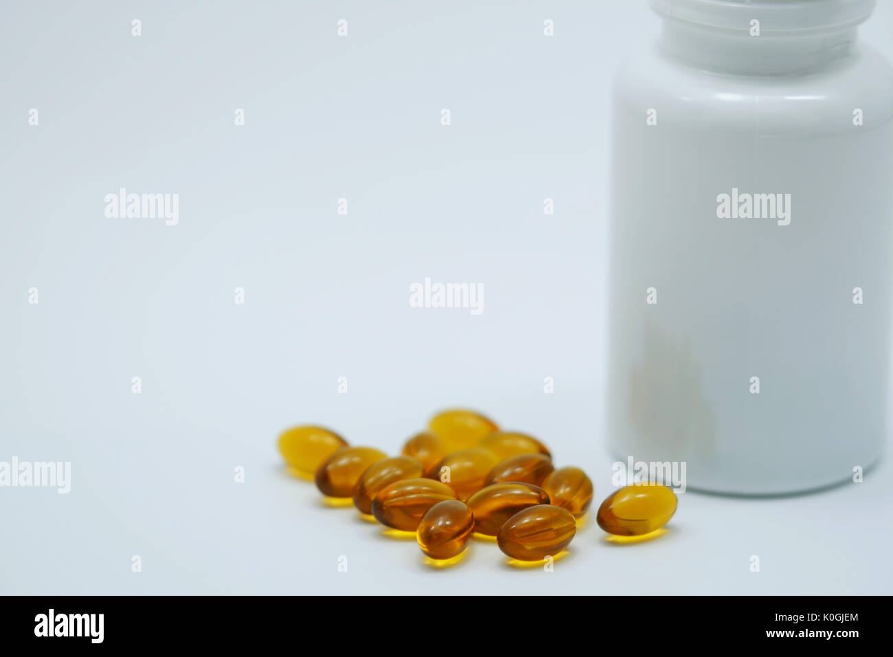 Brown capsula di gelatina soffice con bottiglia su sfondo bianco con copia spazio e etichetta vuota. La vitamina e concetto di supplemento Foto Stock