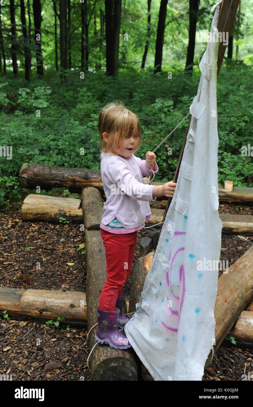 Bambina gioca a far finta di barca a vela nella scuola di foresta vicino a Charlbury, Oxfordshire. U.K. Foto Stock