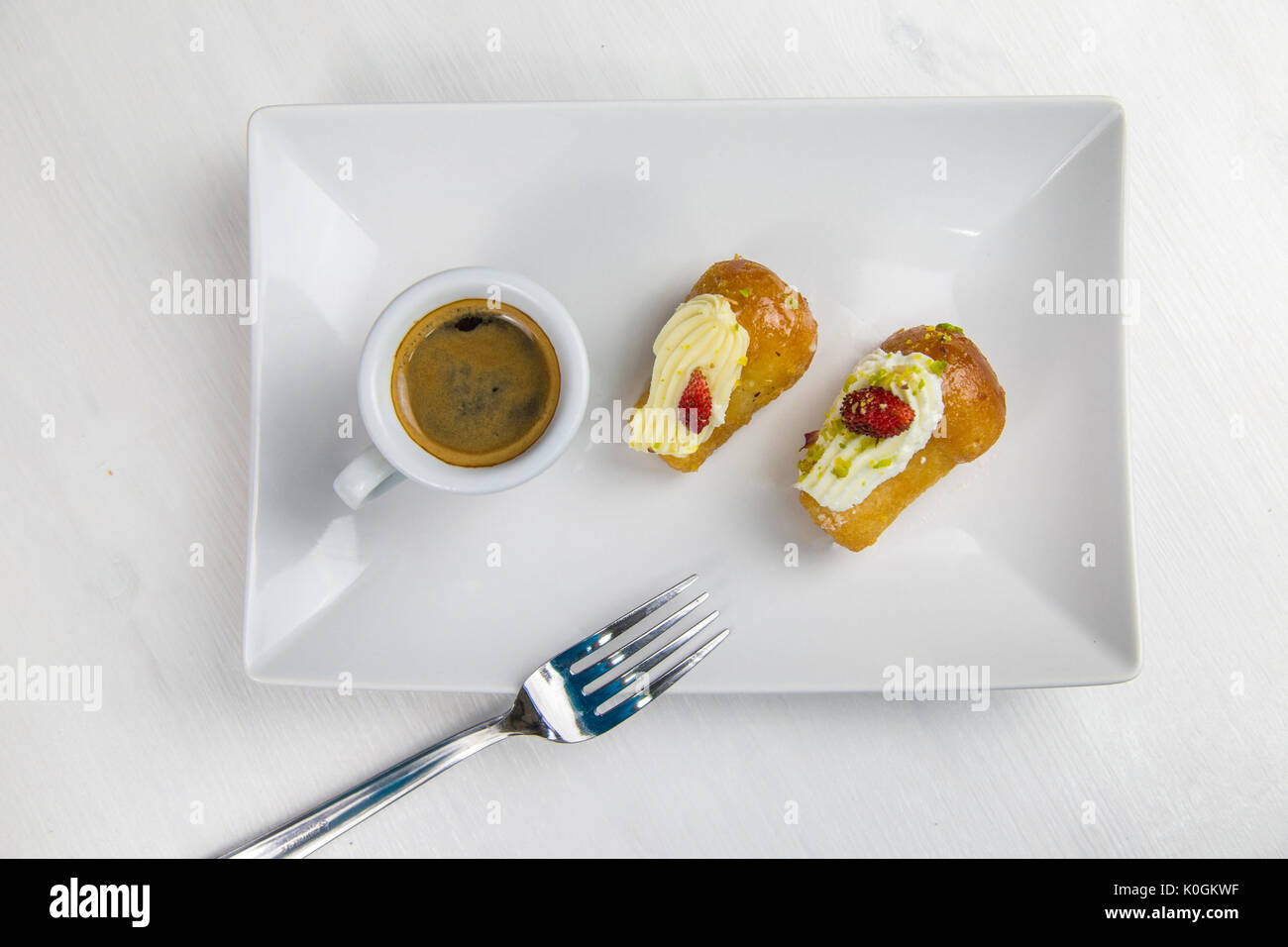 Babà napoletano e caffè sul bianco piatto bianco Foto Stock