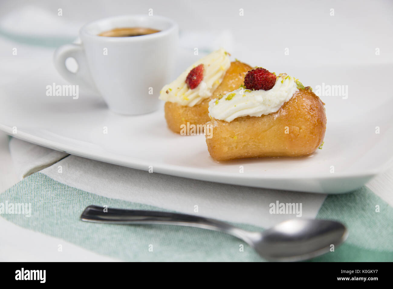 Babà napoletano e caffè sul bianco piatto bianco Foto Stock