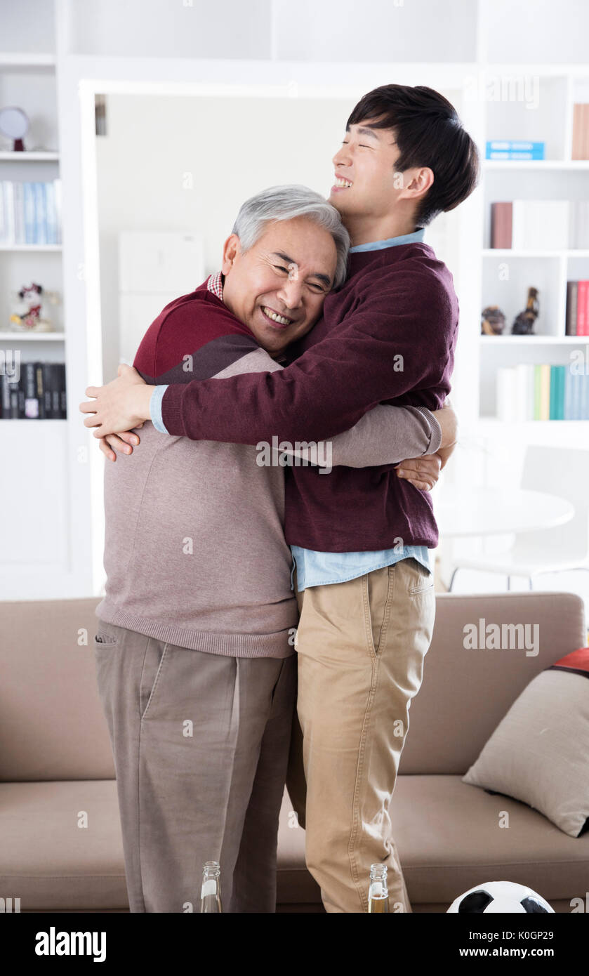 Sorridente uomo senior e il suo giovane figlio avvolgente Foto Stock