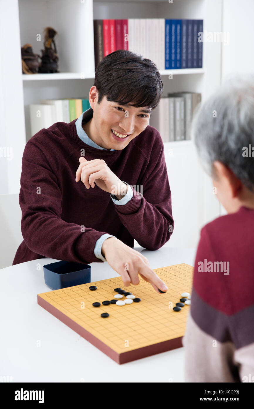 Ritratto di giovane figlio e il suo anziano padre giocando vai Foto Stock