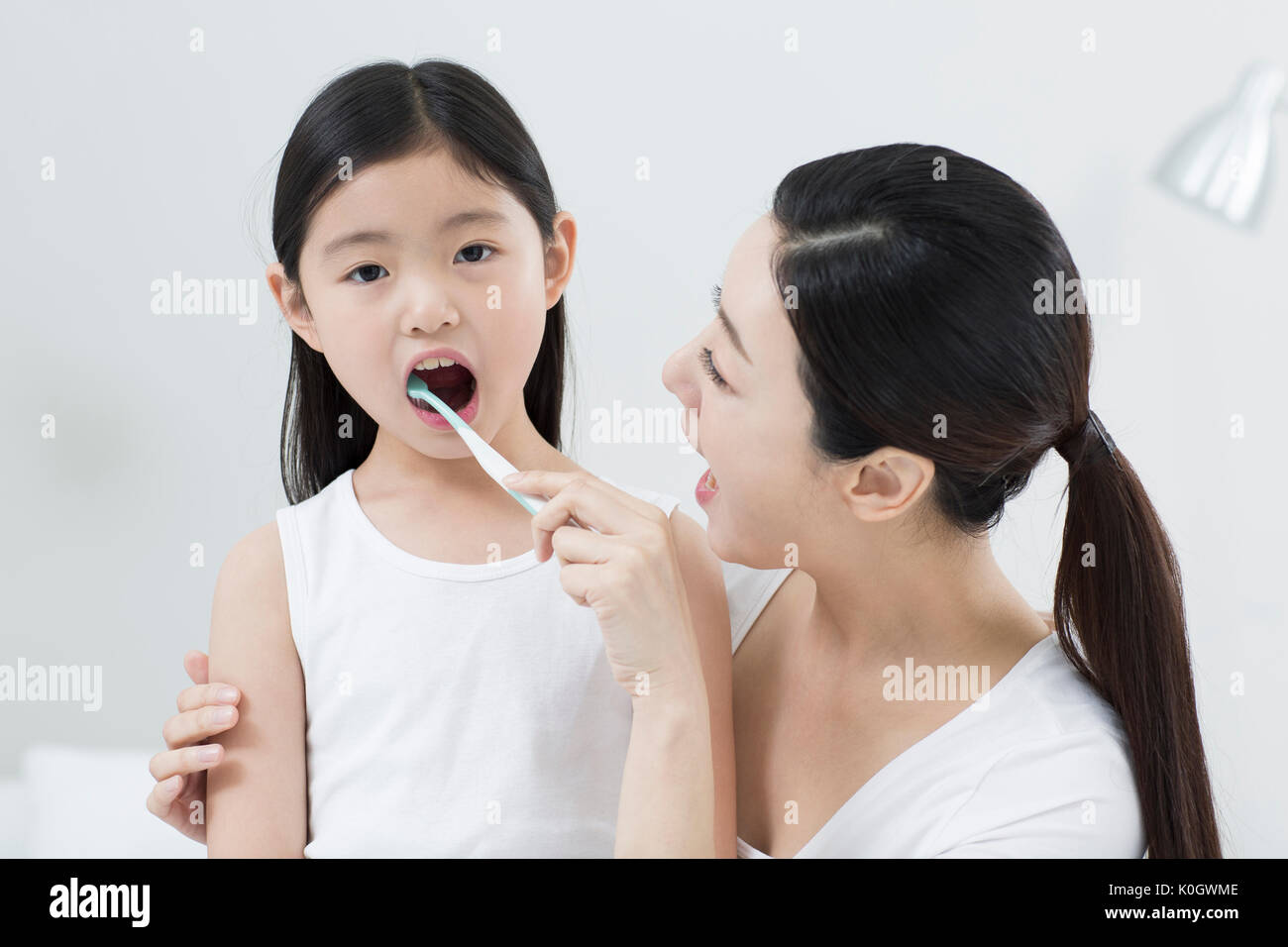 Ritratto di madre aiutare la propria figlia spazzola denti Foto Stock