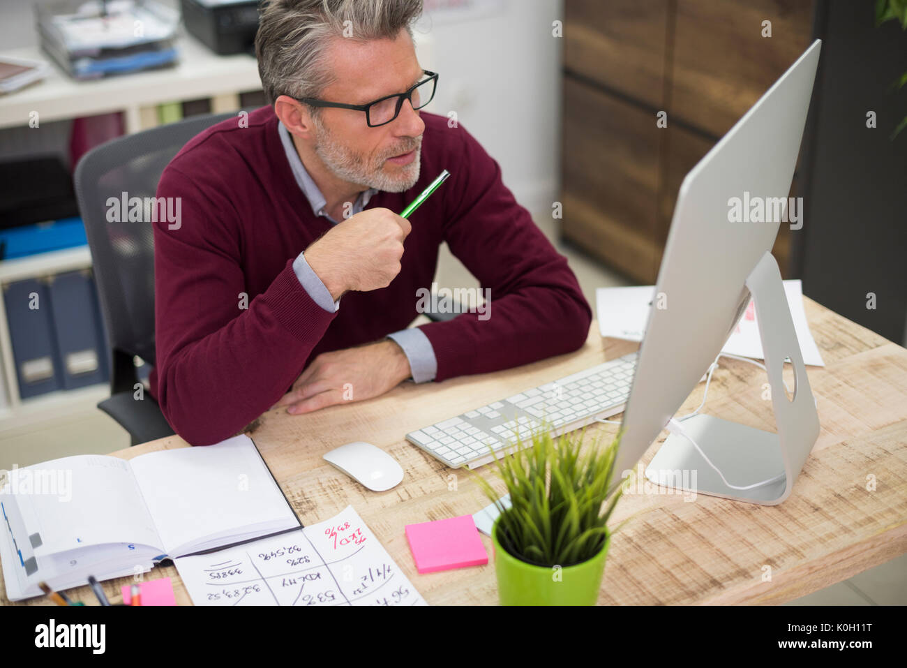 Lavoratore focalizzato in ufficio interno Foto Stock