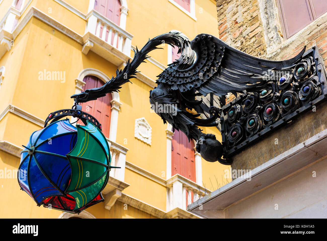 Un insolito lampione avvistato a Venezia. Un drago azienda più ombrelloni. Foto Stock