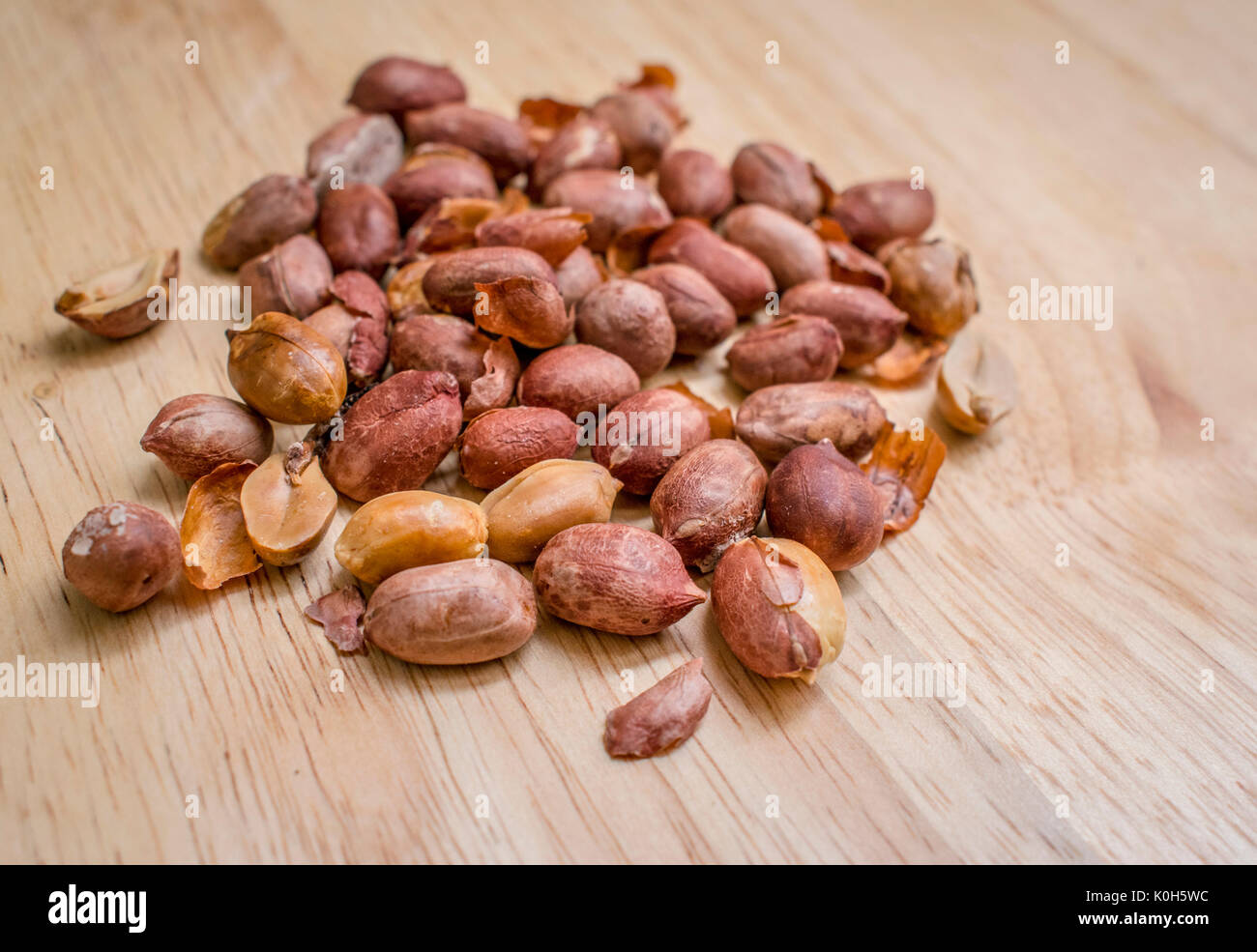Cotti e arachidi salate sulla parte superiore di un tagliere di legno Foto Stock
