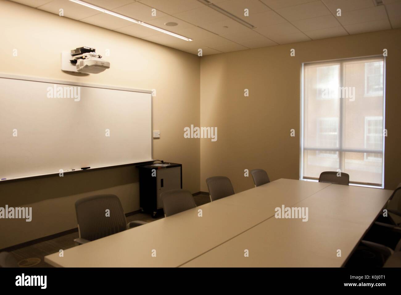Una sala di studio di brody learning commons con un grande vuoto tavola bianco circondato da tavoli grigio, una lavagna e una finestra con le sue tende non disegnate, 2016. cortesia eric chen. Foto Stock