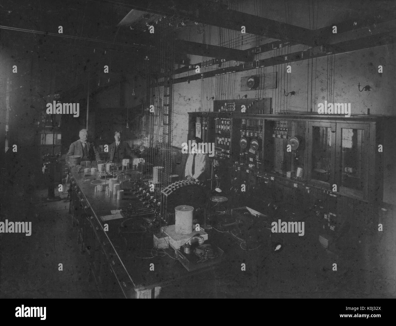 Interno del laboratorio con tre persone in Johns Hopkins University campus vecchio edificio di Fisica, 1890. Foto Stock
