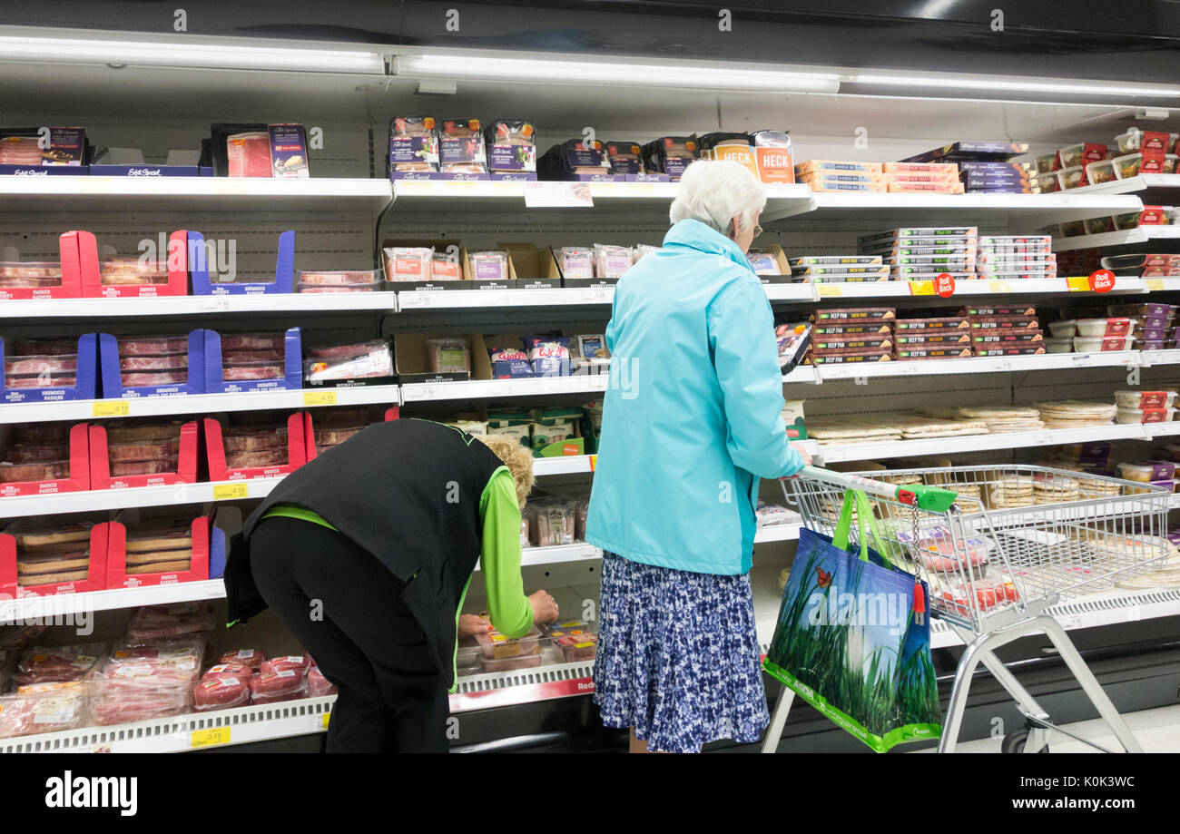 Femmina matura Asda dipendente nel supermercato Asda. Regno Unito Foto Stock