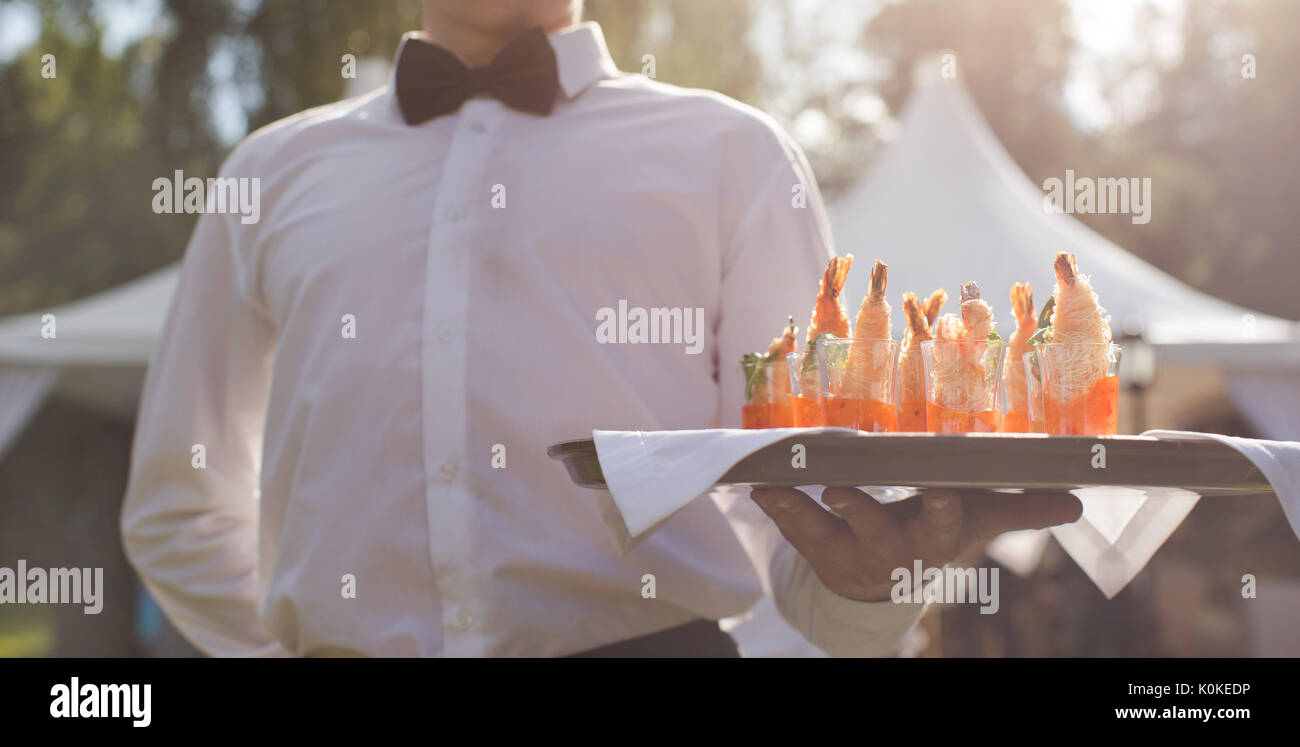Cameriere a piedi con antipasti Foto Stock