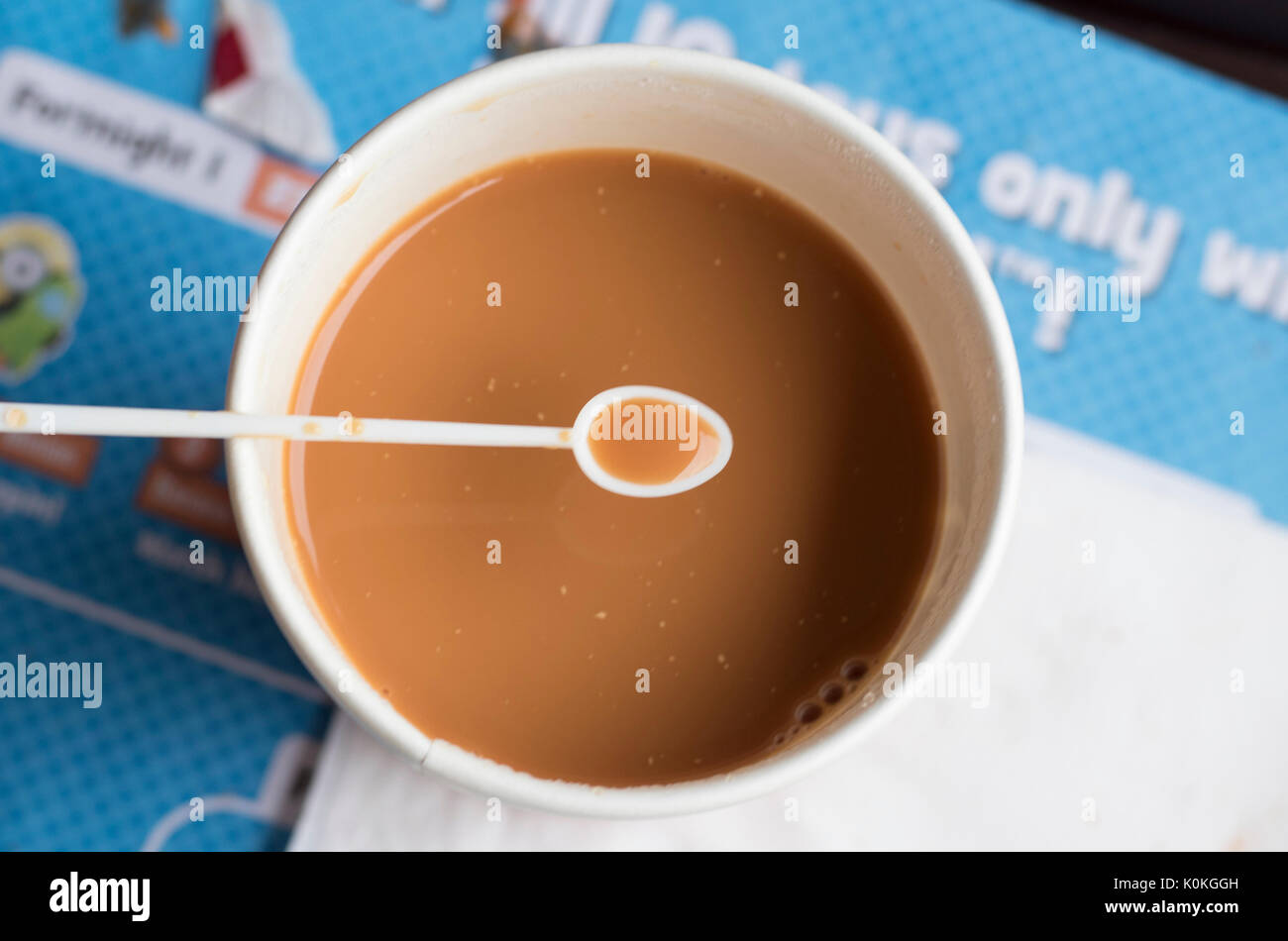 Un cucchiaio colmo di tè mantenuto al di sopra di una tazza piena di tè Foto Stock