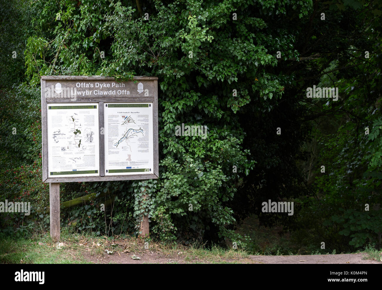Segno che puntano a Offa's Dyke percorso (Llwybr Clawdd Off) accanto al fiume Wye inil città di Hay on Wye. Foto Stock