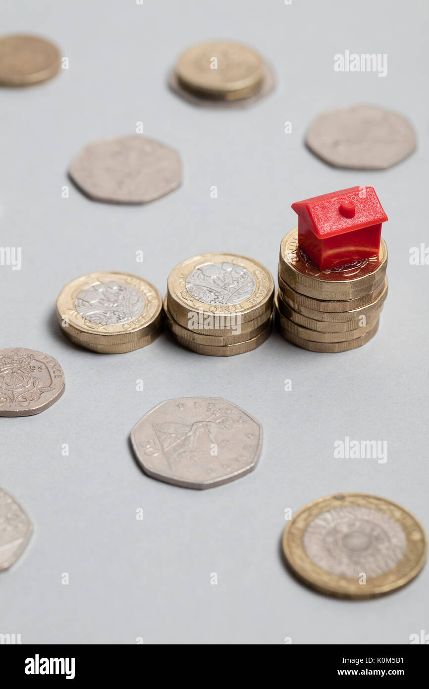 Costo di alloggiamento. Casa Rossa con la valuta britannica Foto Stock