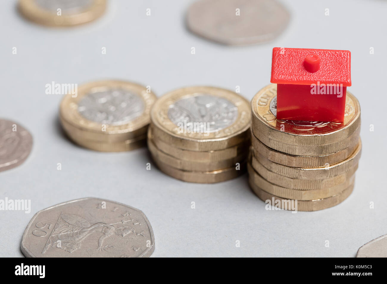 Costo di alloggiamento. Casa Rossa con la valuta britannica Foto Stock