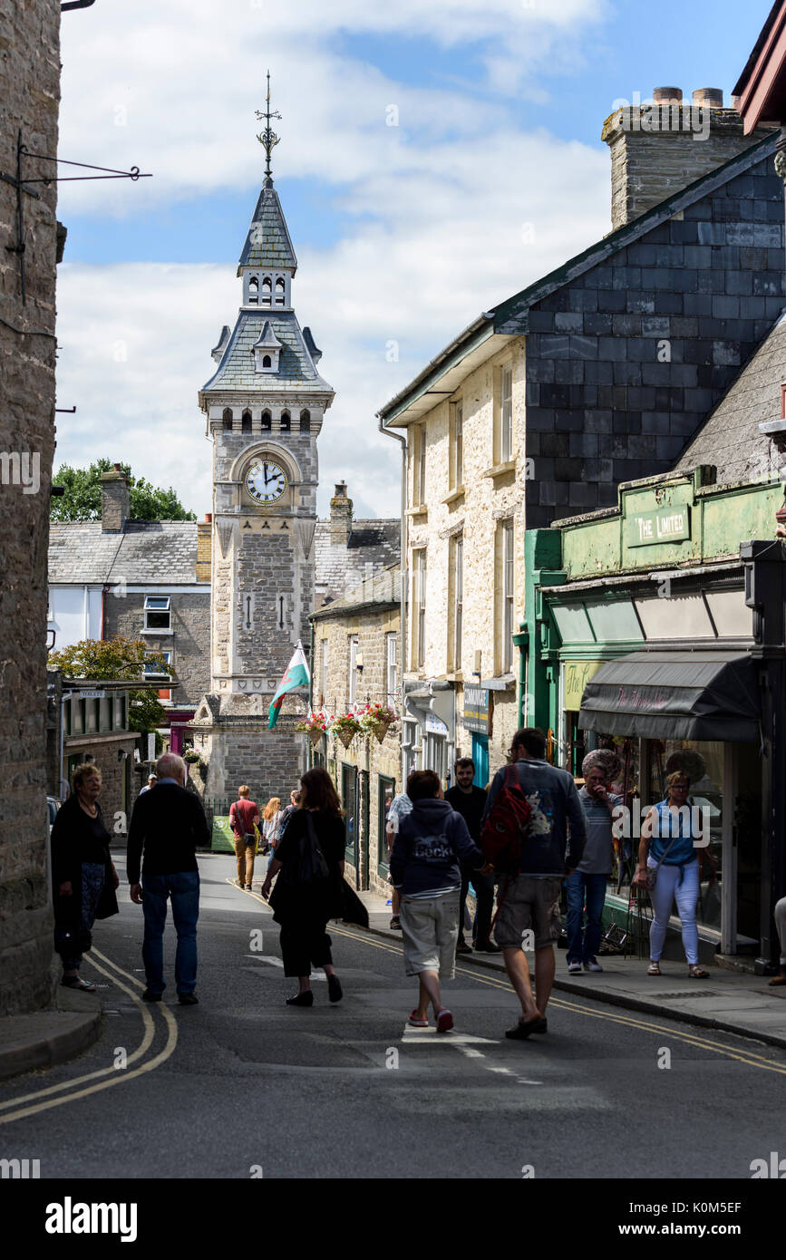 Visitatori camminare lungo una strada con il clock di città in background a Hay on Wye, una piccola città sul confine di Inghilterra e Galles. Foto Stock