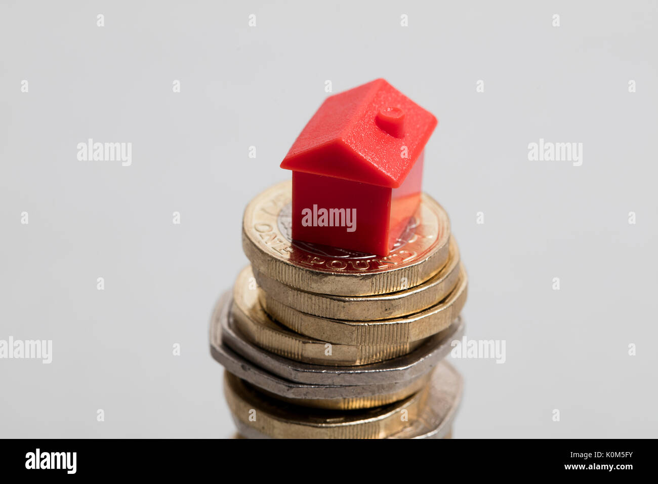 Costo di alloggiamento. Casa Rossa con la valuta britannica Foto Stock