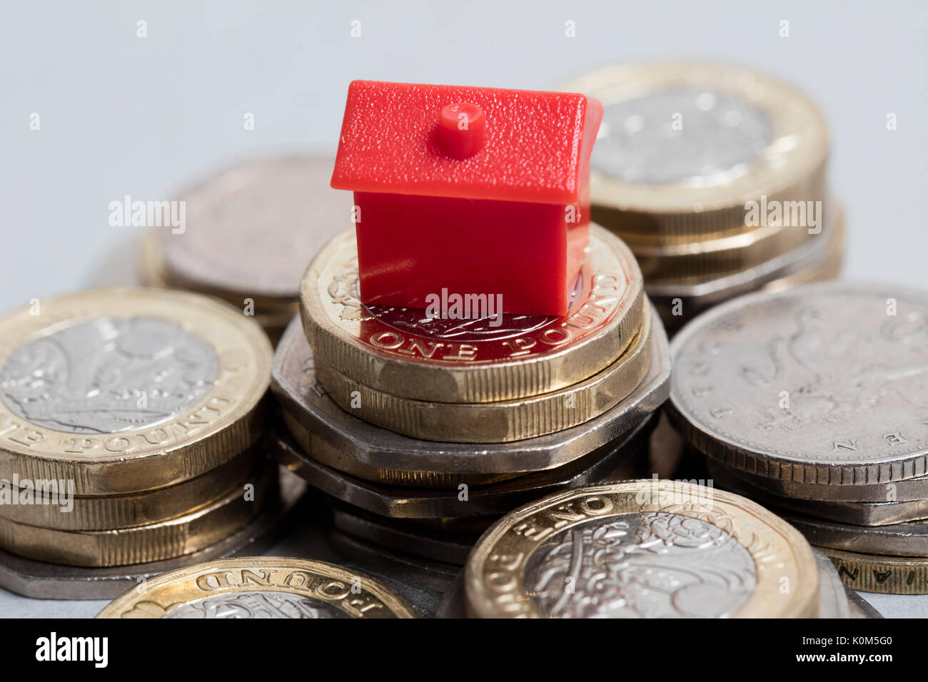 Costo di alloggiamento. Casa Rossa con la valuta britannica Foto Stock