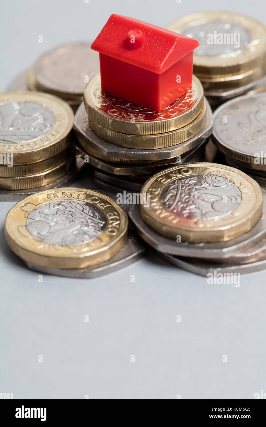 Costo di alloggiamento. Casa Rossa con la valuta britannica Foto Stock