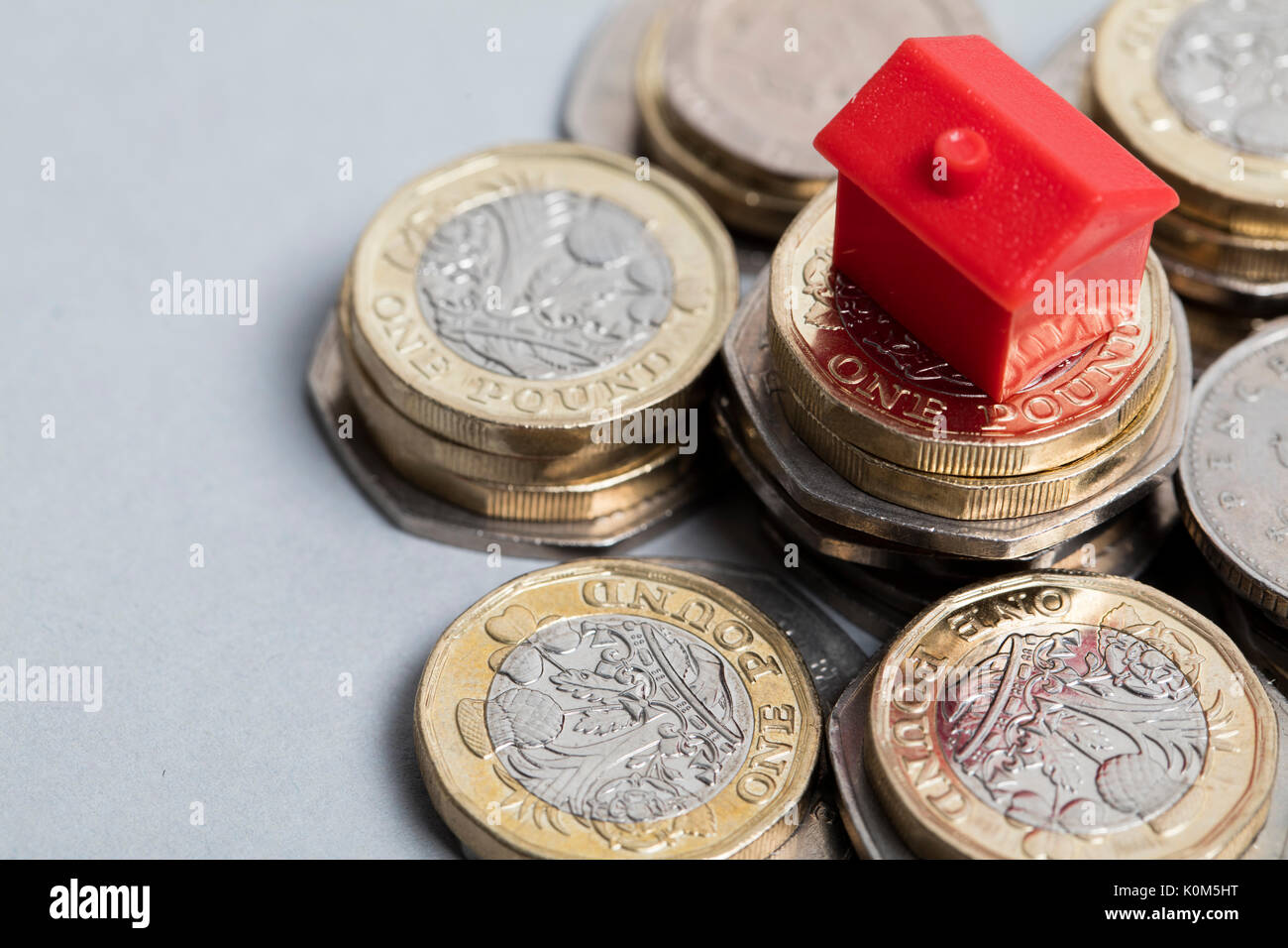 Costo di alloggiamento. Casa Rossa con la valuta britannica Foto Stock