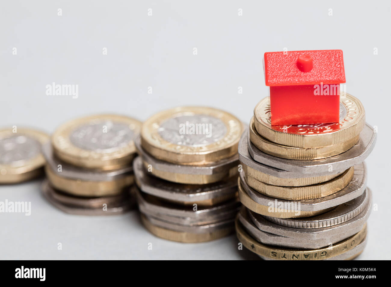Costo di alloggiamento. Casa Rossa con la valuta britannica Foto Stock