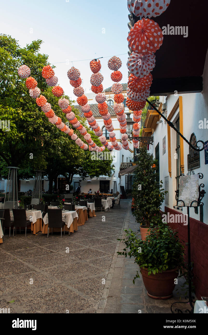 Decorazioni appeso su un quadrato di Barrio de Santa Cruz, quartiere ebraico di Siviglia medievale, pronto per la Feria de abril, la famosa fiera Foto Stock