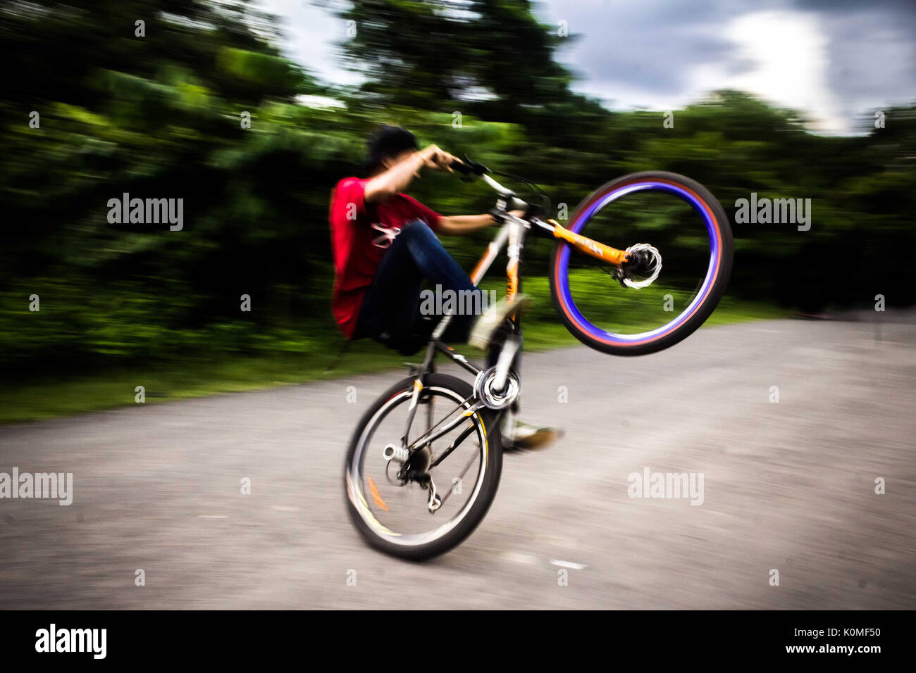 Ragazzo giovane facendo per ciclo Acrobazie, Calcutta, West Bengal, India, Asia Foto Stock