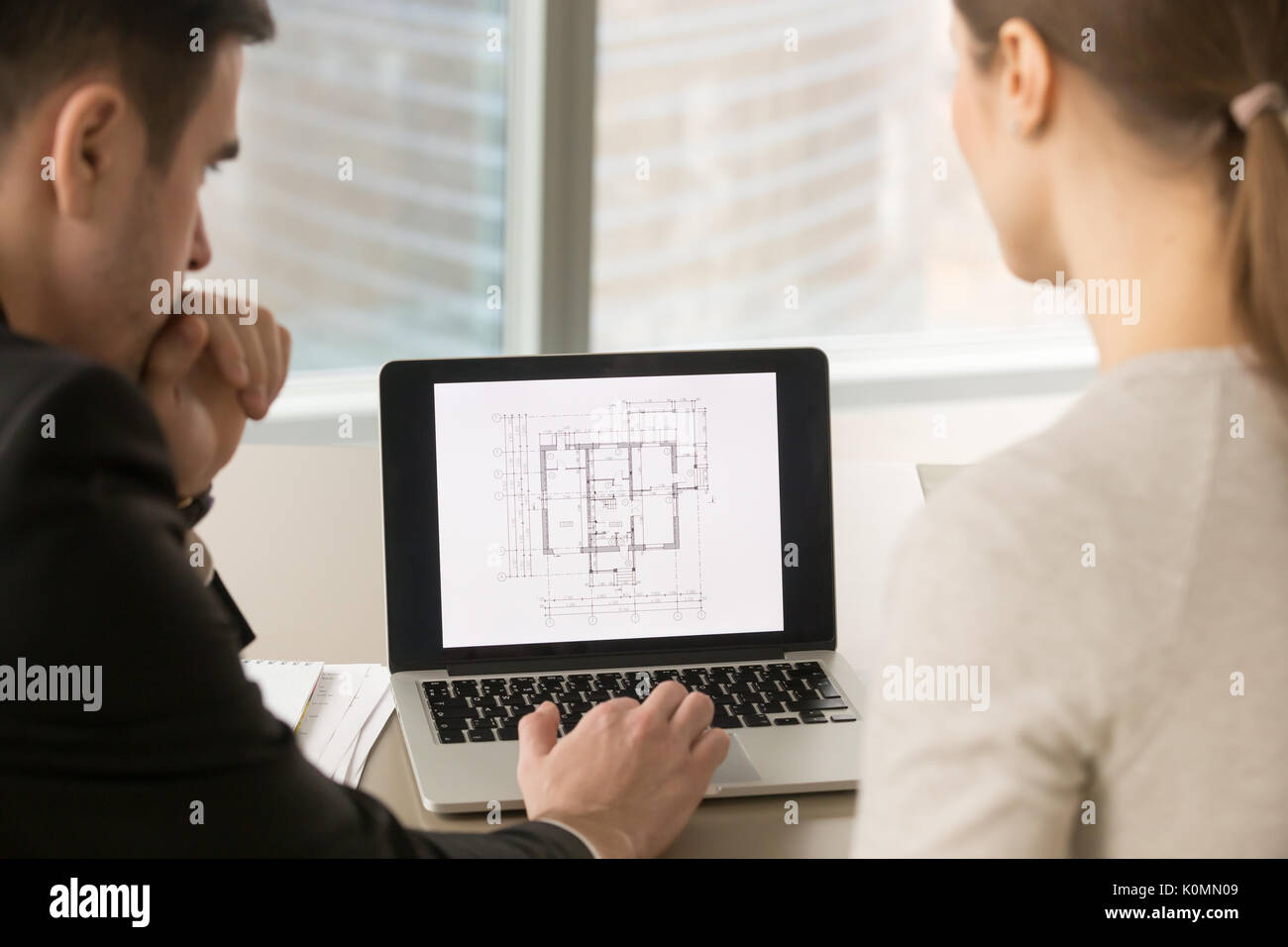 Gli architetti che lavorano con piano di costruzione su schermo portatile, close up Foto Stock