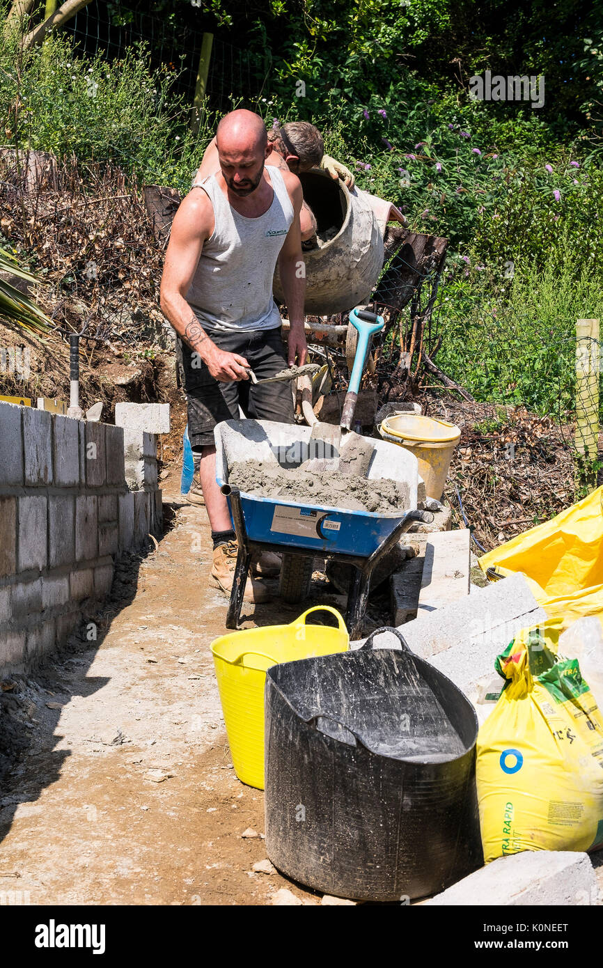Lavoratori la costruzione di una parete del blocco su un sito di costruzione. Foto Stock