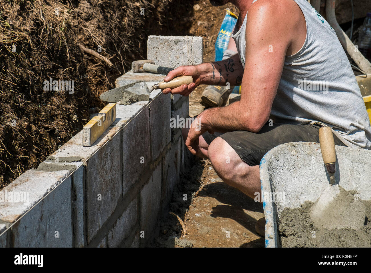 Lavoratori la costruzione di una parete del blocco su un sito di costruzione. Foto Stock